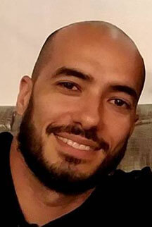 a man with a beard smiles at the camera